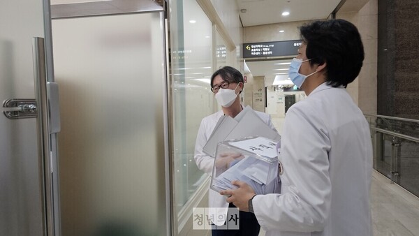 Professors at Korea University Anam Hospital, including Professor Han Byung-duk of the Department of Family Medicine, delivered the resignation letters collected Monday to their hospital’s general affairs office. (KBR photo)